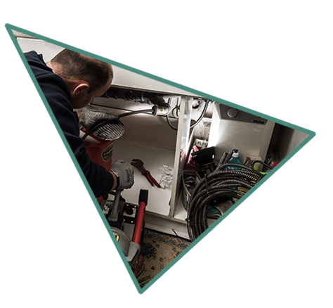 Techniker Entstopft den Küchenablauf mit einer Reinigungsfeder.